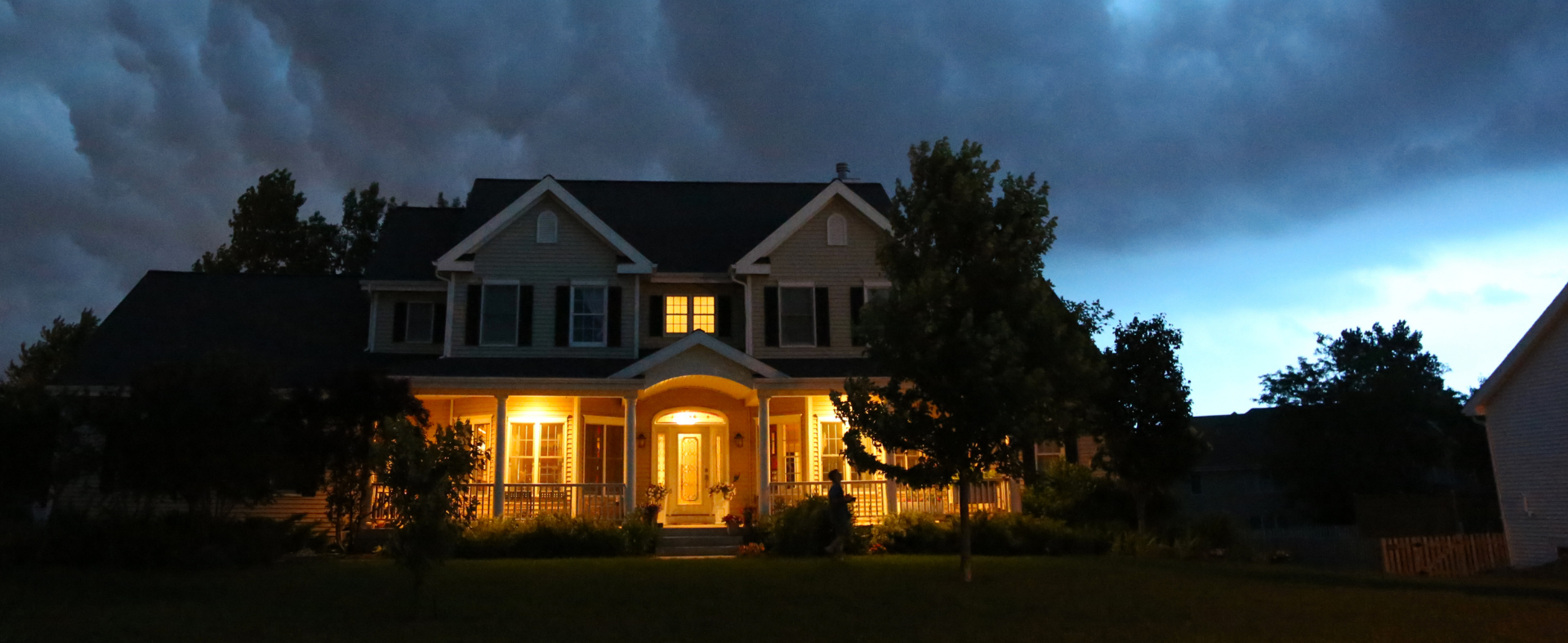 House at night in stormy weather with lights on