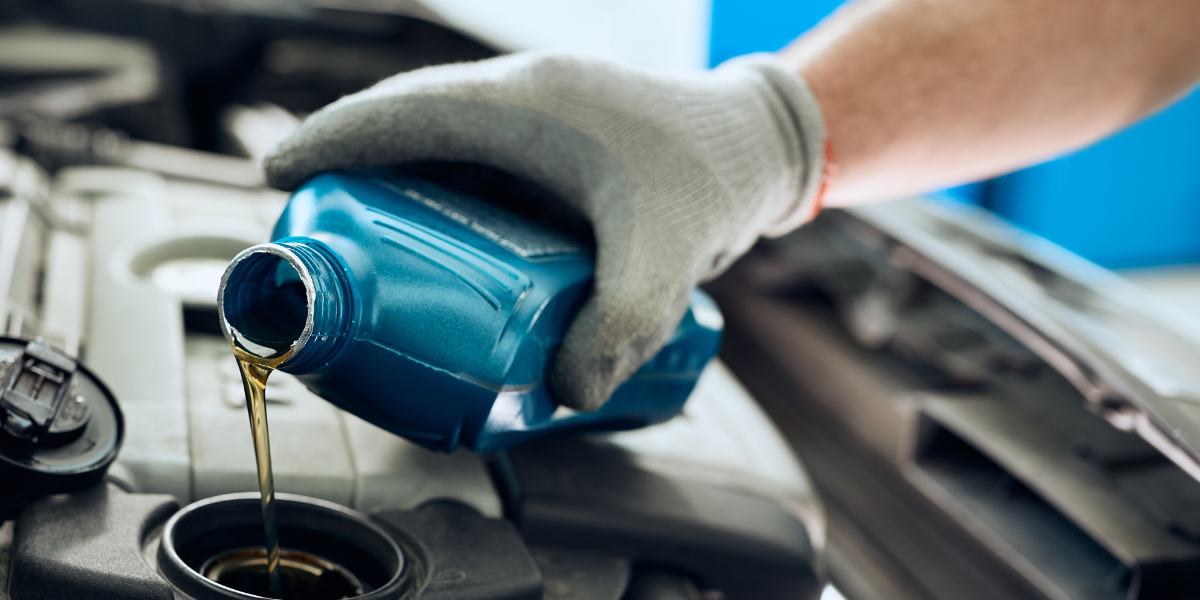 Person pouring oil into car