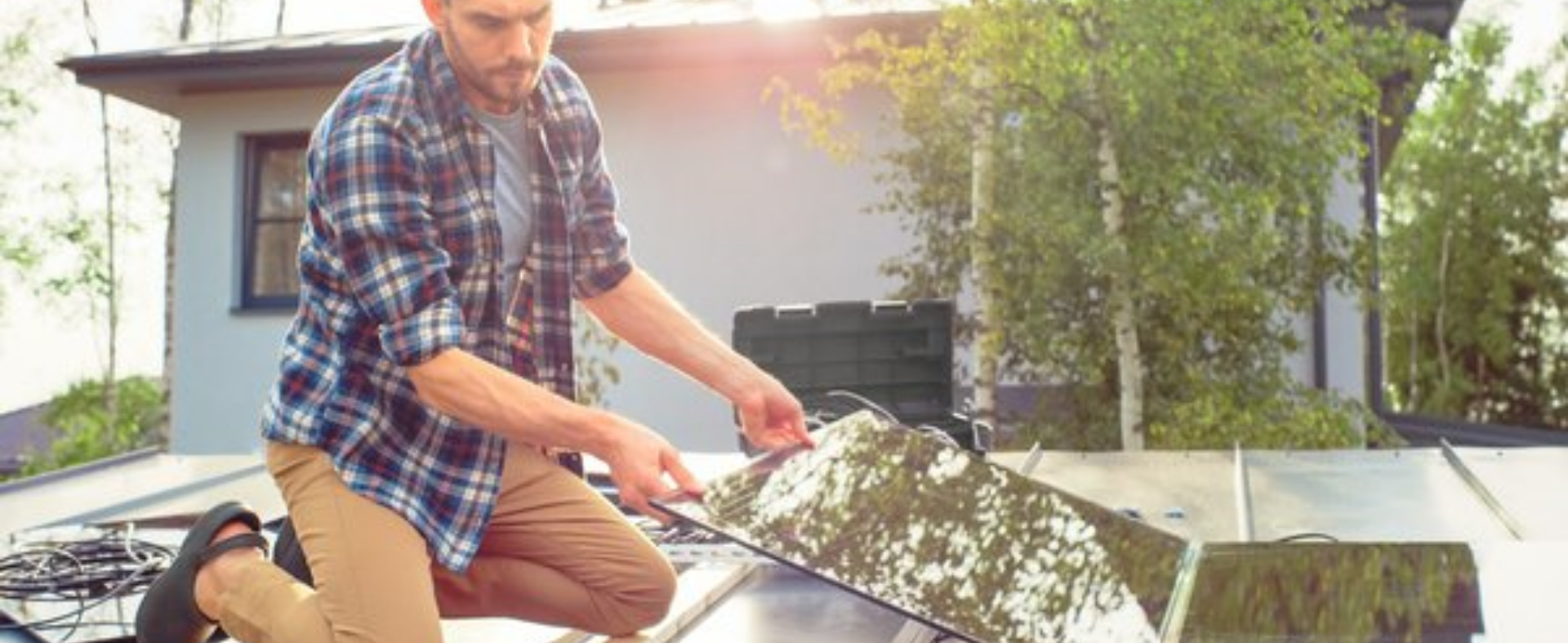 Man installing solar panels on roof