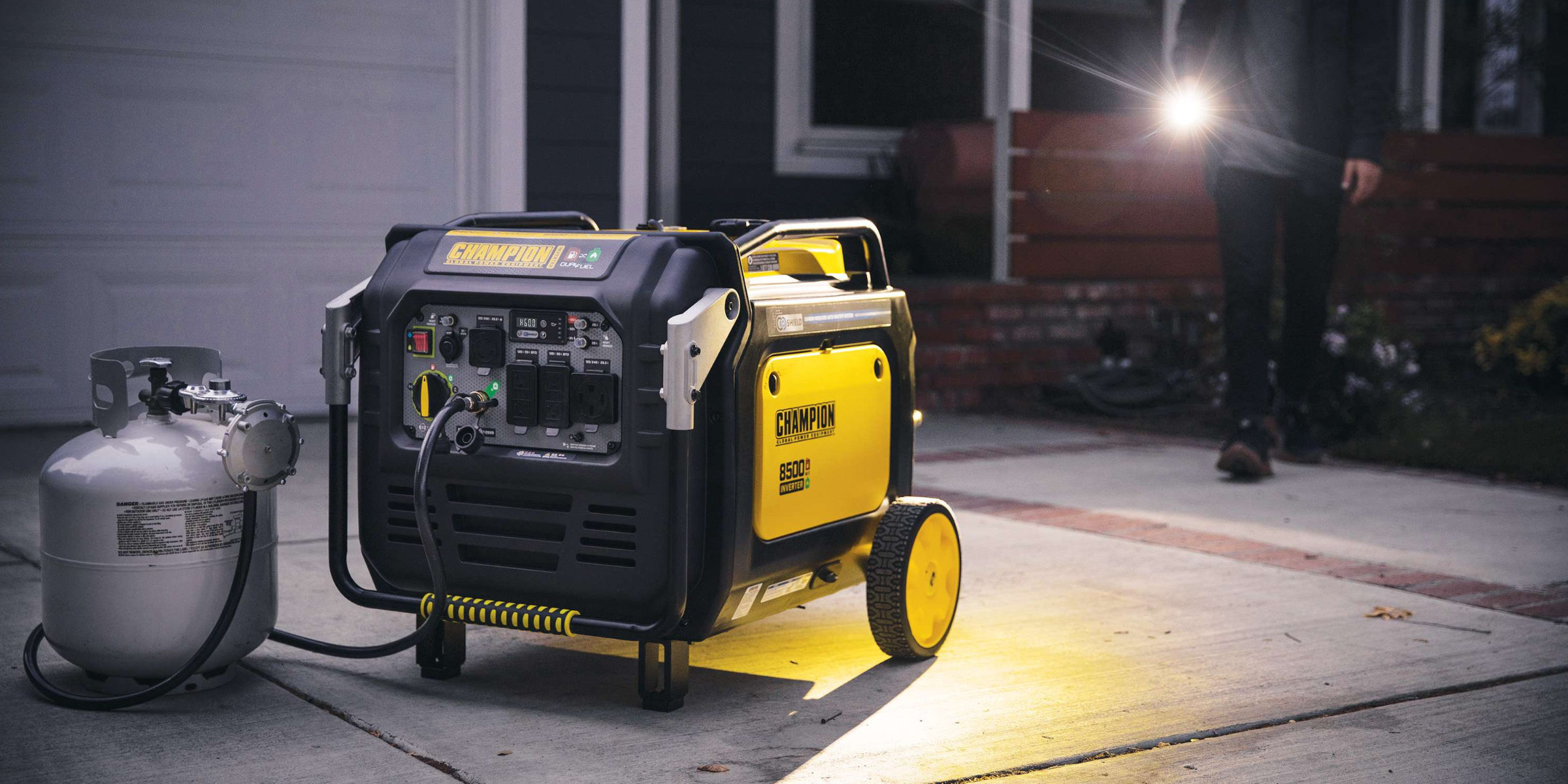 Champion generator at night showing man with flashlight in driveway.